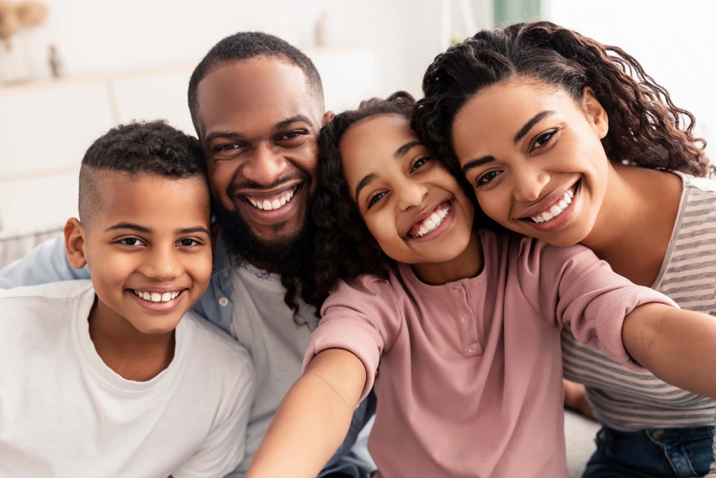 Portrait of happy african american family taking a selfie together at home